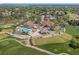 Aerial photograph highlighting a golf course community's pool, clubhouse, and parking, surrounded by greenery at 2050 Quailwood Ln, Spring Hill, FL 34606