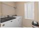 Bright laundry room with a modern washer and dryer set and a white mini-blind at 2124 Godfrey Ave, Spring Hill, FL 34609