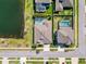 Aerial view of houses with backyard pools and lush landscaping near a serene lake at 21804 Briske Morning Ave, Land O Lakes, FL 34637