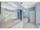 Bright bathroom featuring double sinks, mirrors, and tiled floor with a view of the bath at 2764 Countryside Blvd # 3, Clearwater, FL 33761