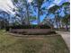 Westchester Lake community entrance with brick signage, manicured landscaping, and mature trees under a sunny, partly cloudy sky at 2764 Countryside Blvd # 3, Clearwater, FL 33761