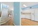 Foyer with staircase leading upstairs, and a peek into the white kitchen with tile floors at 2764 Countryside Blvd # 3, Clearwater, FL 33761