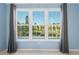 Window view of trees and ponds, with grey curtains at 2764 Countryside Blvd # 3, Clearwater, FL 33761