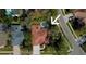 Aerial view of a single-story home with terracotta roof tiles and a screened-in pool surrounded by lush greenery at 2806 Grey Oaks Blvd, Tarpon Springs, FL 34688