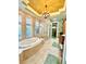 Luxurious bathroom featuring a standalone tub, a glass-enclosed shower, and dual vanities at 2806 Grey Oaks Blvd, Tarpon Springs, FL 34688