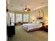 Cozy bedroom with a tropical theme, featuring plantation shutters and a ceiling fan at 2806 Grey Oaks Blvd, Tarpon Springs, FL 34688