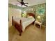 Bedroom featuring a four-poster bed, vibrant wallpaper, and large windows at 2806 Grey Oaks Blvd, Tarpon Springs, FL 34688