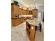 Kitchen island with granite countertops, seating, and wood cabinets at 2806 Grey Oaks Blvd, Tarpon Springs, FL 34688