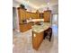 Kitchen island with granite countertops, seating, and wood cabinets at 2806 Grey Oaks Blvd, Tarpon Springs, FL 34688