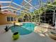 Screened in pool area with tropical landscaping providing a relaxing backyard oasis at 2806 Grey Oaks Blvd, Tarpon Springs, FL 34688