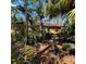 Exterior shot of a home surrounded by tropical landscaping and mature trees at 2806 Grey Oaks Blvd, Tarpon Springs, FL 34688