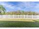 A grassy yard is enclosed with a tall, white picket fence at 28752 Falling Leaves Way, Wesley Chapel, FL 33543