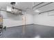 Large garage with epoxy flooring, overhead lighting, and ample storage space at 28752 Falling Leaves Way, Wesley Chapel, FL 33543