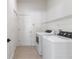 Clean laundry room with modern appliances, tile flooring, and wire shelving at 28752 Falling Leaves Way, Wesley Chapel, FL 33543