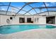 Screened pool and patio with travertine deck, surrounded by a bright white exterior, perfect for outdoor enjoyment at 288 Alpine Ct, Palm Harbor, FL 34683