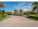 Community clubhouse with a welcoming brick driveway, lush landscaping, and palm trees, showcasing a luxurious neighborhood amenity at 3130 Forsythia Dr, Odessa, FL 33556