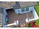 Aerial view of an outdoor courtyard with brick pavers, patio furniture, stone walls, and tropical plants at 3130 Forsythia Dr, Odessa, FL 33556