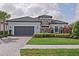Charming single-story home with gray garage door, stone accents, and lush landscaping at 3130 Forsythia Dr, Odessa, FL 33556