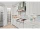 Stylish kitchen with white cabinets, stainless steel hood, subway tile backsplash, and walk-in pantry at 3130 Forsythia Dr, Odessa, FL 33556