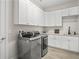 Modern laundry room boasts stainless steel washer and dryer, ample cabinet space, and stylish countertops at 3130 Forsythia Dr, Odessa, FL 33556