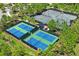Aerial view showcasing multiple fenced tennis courts available within the community at 3130 Forsythia Dr, Odessa, FL 33556