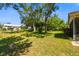 A lush backyard with mature trees and shrubs, and lots of green grass and shade at 3273 Bluestone Ave, Spring Hill, FL 34609