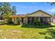 A view of the backyard features an enclosed porch area and established landscaping on a well-maintained lawn at 3273 Bluestone Ave, Spring Hill, FL 34609