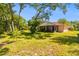 The house includes a spacious backyard featuring mature trees and established landscaping at 3273 Bluestone Ave, Spring Hill, FL 34609