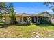 A lush backyard setting showcases a well-kept lawn and mature plantings around the home's exterior at 3273 Bluestone Ave, Spring Hill, FL 34609