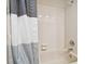 Neutral bathroom showcasing a shower-tub combo with tile surround and a striped curtain at 3273 Bluestone Ave, Spring Hill, FL 34609