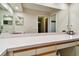 A look at the expansive bathroom vanity with white countertops, large mirror, and view to the shower at 3273 Bluestone Ave, Spring Hill, FL 34609