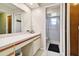 Bathroom vanity with white countertop, cabinet storage, and shower visible through open door at 3273 Bluestone Ave, Spring Hill, FL 34609