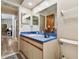 Bathroom with a blue countertop, a large mirror, and neutral cabinets at 3273 Bluestone Ave, Spring Hill, FL 34609