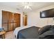Comfortable bedroom features a ceiling fan, television, closet and wood floors at 3273 Bluestone Ave, Spring Hill, FL 34609