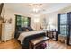 Inviting bedroom with a ceiling fan, dark linens, a window and wooden floors at 3273 Bluestone Ave, Spring Hill, FL 34609