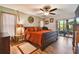 Spacious bedroom with wood floors, ceiling fan and glass sliding doors to outside patio at 3273 Bluestone Ave, Spring Hill, FL 34609