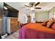 Bedroom with a large TV, wood floors, ceiling fan and adjoining bathroom and closet at 3273 Bluestone Ave, Spring Hill, FL 34609