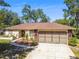 The house's exterior is accented by beautiful landscaping, an arched entryway, and a multi-car garage at 3273 Bluestone Ave, Spring Hill, FL 34609