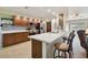 Well-lit kitchen with stainless steel appliances, wood cabinets, a breakfast bar, and neutral tile flooring at 3273 Bluestone Ave, Spring Hill, FL 34609