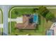 Overhead view showcases a pristine home with solar panels, screened pool, and manicured lawn at 3542 Conifer Loop, Spring Hill, FL 34609