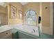 Bright bathroom with a large soaking tub beneath an arched window providing natural light at 3542 Conifer Loop, Spring Hill, FL 34609