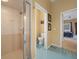 Bathroom featuring a glass-enclosed shower, toilet, and entry to the primary bedroom at 3542 Conifer Loop, Spring Hill, FL 34609