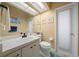 Well-lit bathroom with a clean white vanity, toilet, and beach-themed decorations at 3542 Conifer Loop, Spring Hill, FL 34609