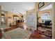 Elegant entryway with rich hardwood floors, a bar, and decorative glass doors leading to a bright office at 3542 Conifer Loop, Spring Hill, FL 34609