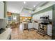 Bright kitchen with stainless steel appliances, white cabinets, tile floors, and an open layout connecting to the breakfast nook at 3542 Conifer Loop, Spring Hill, FL 34609