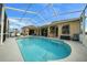 An outdoor pool with a screened enclosure and outdoor seating at 3542 Conifer Loop, Spring Hill, FL 34609