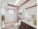 Charming bathroom with pink tub, shower, and toilet, complimented by a dark wood vanity at 3730 Sail Dr, New Port Richey, FL 34652