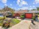Charming single-story home with a red garage door, arched entry, and well-maintained landscaping at 3730 Sail Dr, New Port Richey, FL 34652