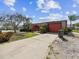 Charming single-story home featuring a red garage door and unique arched entry gate at 3730 Sail Dr, New Port Richey, FL 34652