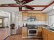 Kitchen features custom cabinets, stainless steel appliances, granite counters, and designer ceramic tile flooring at 3730 Sail Dr, New Port Richey, FL 34652